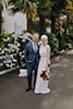 bride and groom happily standing in their vibrant red florals- Nelson Wedding