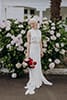 Bride standing happily with her vibrant red florals- Nelson Wedding