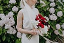 bride with her vibrant red florals- Nelson Wedding