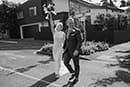 black and white shot of bride and groom happily walking on the road- Nelson Wedding